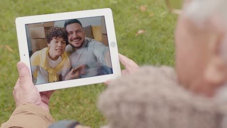 Elder-Man-Holding-A-Tablet-And-Making-Videocall-Standing-In-The-Park,-Couple-Greeting-The-Other-Side-Of-The-Camera