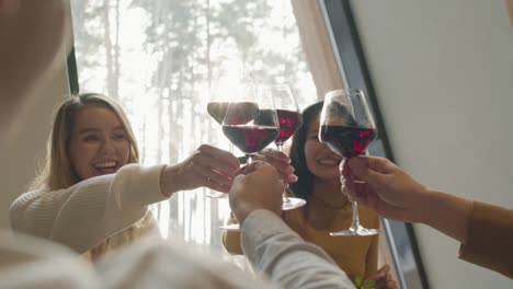 Group-Of-Friends-Toasting-With-Red-Wine-In-A-Restaurant