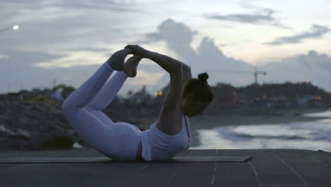 Frau-In-Weißer-Sportbekleidung,-Die-Eine-Yoga-Haltung-Am-Strand-Macht