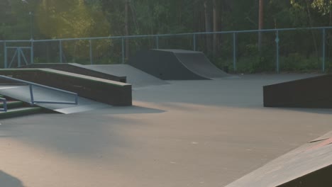Joven-En-Sudadera-Y-Jeans-Practicando-Skateboarding-En-Skate-Park