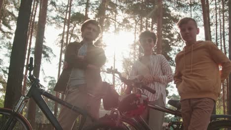 Young-Affectionate-Couple-With-Their-Son-Looking-At-Camera-With-Their-Bicycles-In-Rural-Environment