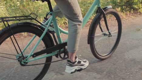 Camera-Focusing-On-The-Feet-Of-A-Woman-Pedaling-A-Bicycle