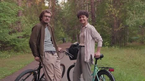 Junges-Liebevolles-Paar-Mit-Ihrem-Sohn,-Der-Mit-Ihren-Fahrrädern-In-Ländlicher-Umgebung-In-Die-Kamera-Schaut-1
