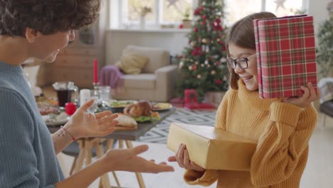 Brunette-Short-Hair-Mother-Gives-Her-Daughter-A-Christmas-Present-In-Living-Room-With-Christmas-Decorations