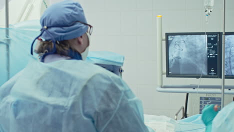 Rückansicht-Eines-Chirurgen,-Der-In-Einem-Operationssaal-Mit-Klinischen-Instrumenten-Und-Monitoren-Operiert