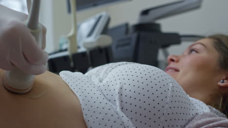 Médico-Con-Guantes-Y-Bata-Blanca-Haciendo-Ultrasonido-A-Una-Mujer-Embarazada