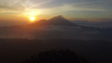 Aerial-View-Of-A-Group-Of-People-On-Top-Of-The-Mountain-At-Sunset