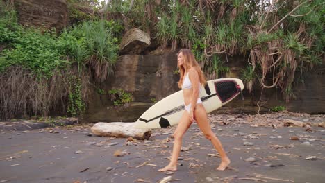 Focused-Beautiful-Girl-Walking-On-A-Sandy-Wild-Beach-With-Her-Surfboard