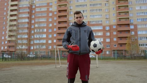 Confident-Male-Soccer-Player-With-Ball-Looking-At-Camera-On-The-Field