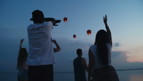 Group-Of-Friends-Saying-Goodbye-With-A-Gesture-To-The-Lanterns-That-Fly-In-The-Sky-At-Night