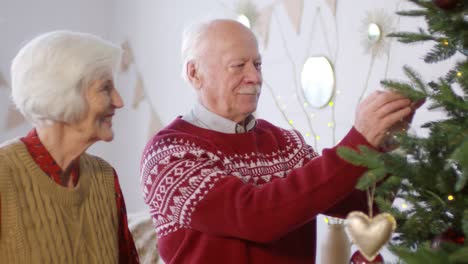 Glückliches-älteres-Paar,-Das-Den-Weihnachtsbaum-Schmückt