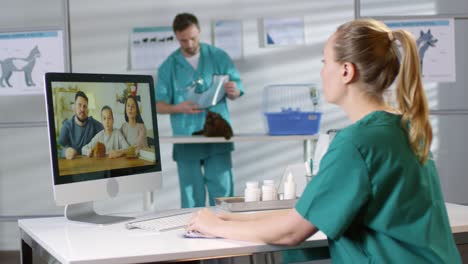 Female-Veterinarian-In-Scrubs-Giving-Online-Consultation-Via-Video-Call-And-Talking-To-A-Family-With-A-Hamster