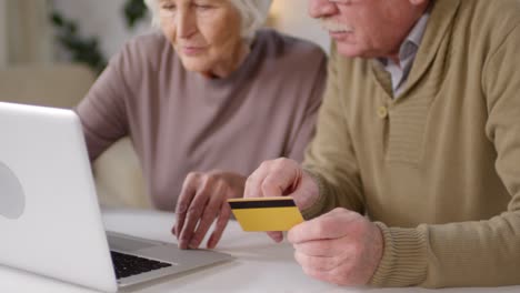 älteres-Paar,-Das-Online-zahlung-Mit-Kreditkarte-Und-Laptop-computer-Macht