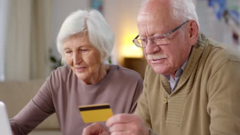 älteres-Paar,-Das-Online-zahlung-Mit-Kreditkarte-Und-Laptop-Macht-1