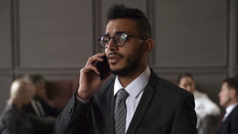 Worried-Middle-Eastern-Businessman-In-Suit-Speaking-On-Mobile-Phone