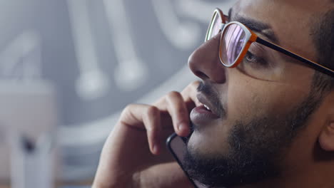 Close-Up-View-Of-Arab-Man-With-Glasses-Sitting-In-The-Studio-Talking-On-The-Phone