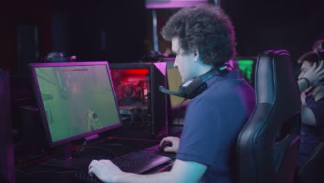 Young-Man-With-Curly-Hair-Playing-Shooter-Game-Round-In-Cybersport-Competition