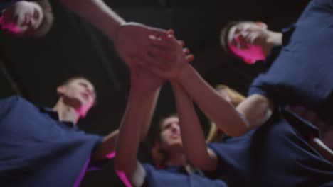 From-Below-View-Shot-Of-Five-Professional-E-Sport-Gamers-Joining-Their-Hands-In-Symbol-Of-Unity-And-Successful-Teamwork