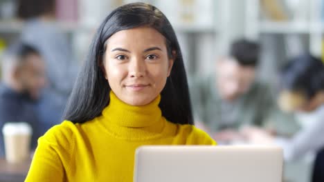 Portrait-Of-A-Pretty-Girl-Smiling-And-Looking-At-Camera-While-Sitting-And-Working-With-Computer-At-Office