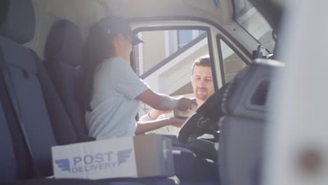 Female-Postal-Service-Courier-Sitting-In-Mail-Van-And-Delivering-Package-To-Man