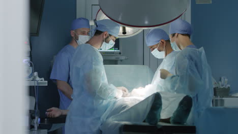 Vier-Konzentrierte-Chirurgen,-Die-Eine-Medizinische-Operation-Am-Patienten-Im-Krankenhaus-Durchführen