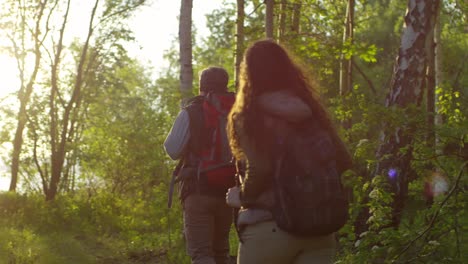 Tourist-Couple-Hiking-In-Forest-At-Sunset