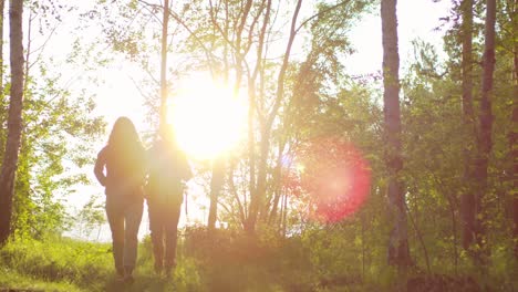 Tourist-Couple-Hiking-In-Forest-At-Sunset-While-Walking-Towards-Camera