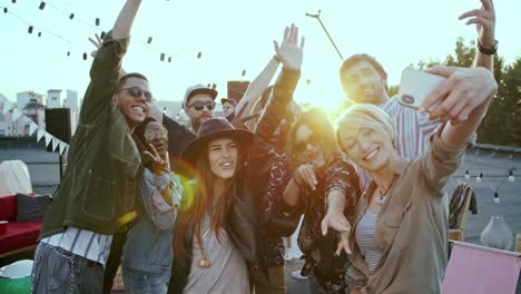 Alegres-Jóvenes-Multiétnicos-Divirtiéndose-Y-Riéndose-Mientras-Posan-Para-La-Cámara-Del-Smartphone-Y-Toman-Selfie-En-La-Fiesta-De-La-Azotea