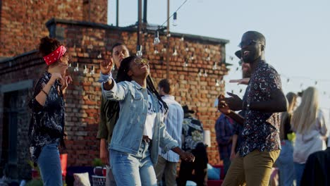 Stylish-Young-Girl-And-Guy-Dancing-Happily-Among-People-At-The-Rooftop-Discotheque-At-Daytime