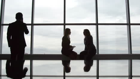 A-Business-Meeting-Between-Two-Women-Backlit-By-A-Large-Window