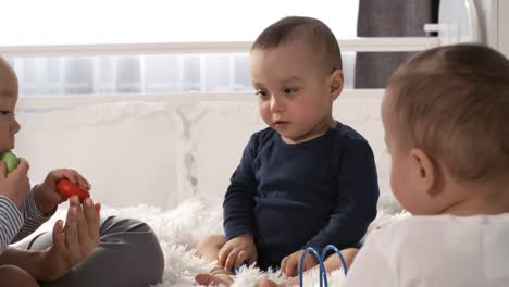 Babydrillinge-Sitzen-Zusammen-Im-Schlafzimmer-Und-Spielen-Mit-Spielzeug