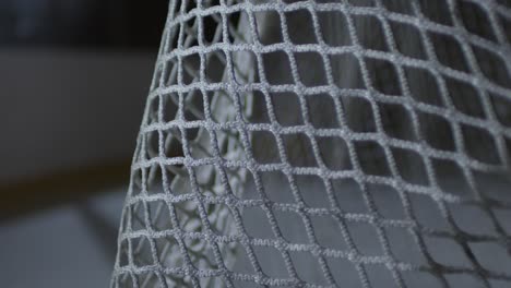 Extreme-Close-Up-Shot-Of-Ice-Hockey-Puck-Hitting-Net-And-Bouncing-Off-During-Game