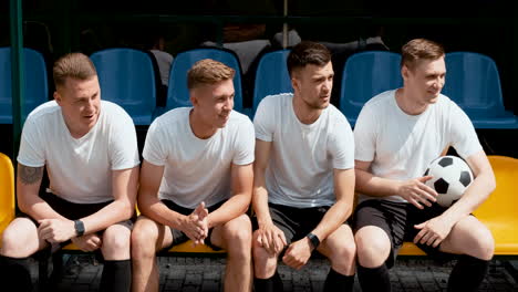 Male-Street-Football-Players-Sitting-On-Bench-And-Watching-The-Match