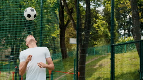 Junger-Männlicher-Fußballspieler,-Der-Ball-Auf-Einem-Straßenfußballplatz-Vorangeht
