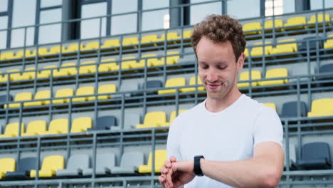 Happy-Sportive-Man-Checking-His-Smartwatch-Before-Outdoor-Training-In-The-Stadium-1
