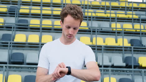 Happy-Sportive-Man-Checking-His-Smartwatch-Before-Outdoor-Training-In-The-Stadium-2