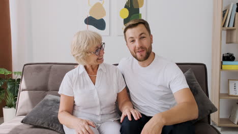 Happy-Mother-With-His-Son-Greeting,-Talking-And-Laughing-Together-On-Video-Call-While-Sitting-On-Sofa-In-Living-Room-And-Looking-At-Camera