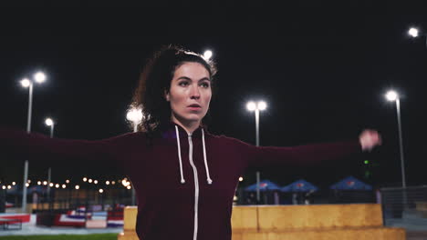 Sportive-Curly-Girl-Stretching-And-Rotating-Arms-In-The-Park-At-Night-4