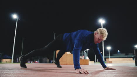Sportive-Blond-Man-Doing-Push-Up-Exercises-In-The-Park-At-Night-1