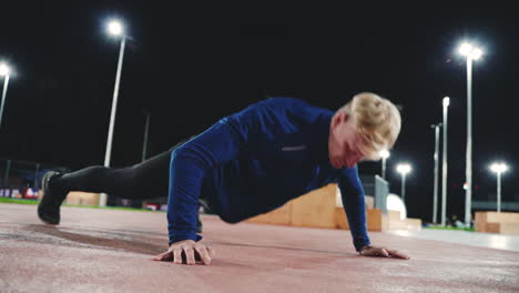 Sportive-Blond-Man-Doing-Push-Up-Exercises-In-The-Park-At-Night-2