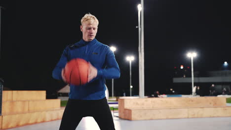 Sportive-Blond-Man-Training-Using-Basketball-In-The-Park-At-Night