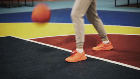 Close-Up-Of-A-Female-Basketball-Player-Bouncing-The-Ball-On-Outdoor-Court-At-Night