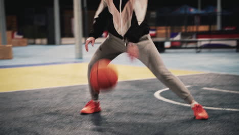 Close-Up-Of-A-Female-Basketball-Player-Training-And-Bouncing-The-Ball-On-Outdoor-Court-At-Night
