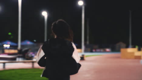 Sportive-Sportswoman-Running-Towards-Camera-In-The-Park-At-Night
