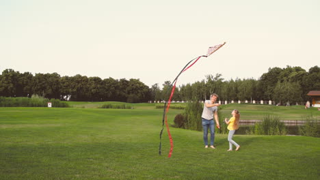 Happy-Father-And-Daughter-Flying-A-Kite-While-Running-Together-On-Meadow-In-A-Park-1