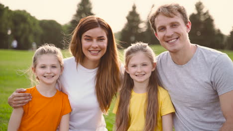Portrait-Of-A-Happy-Family-Smiling-And-Looking-At-Camera-While-Spending-Time-Together-In-The-Park