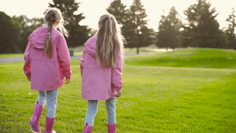 Back-View-Of-Two-Little-Sisters-In-Identical-Clothes-Walking-Together-In-The-Park-On-Autumn-Day