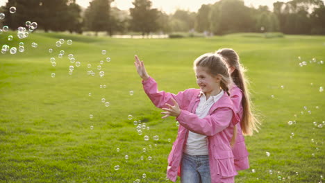 Happy-Little-Sisters-In-Identical-Clothes-Catching-Soap-Bubbles-In-The-Park-3