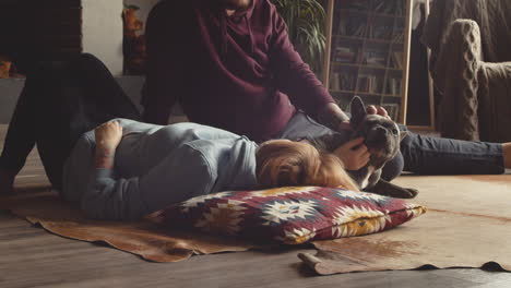 Couple-Caressing-Her-Bulldog-Dog-Liying-On-The-Floor-In-Living-Room-1