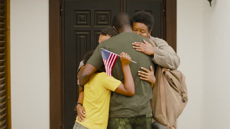 Soldado-Masculino-Abrazando-Y-Despidiéndose-De-Su-Familia-Fuera-De-Casa-Antes-De-Ir-Al-Servicio-Militar